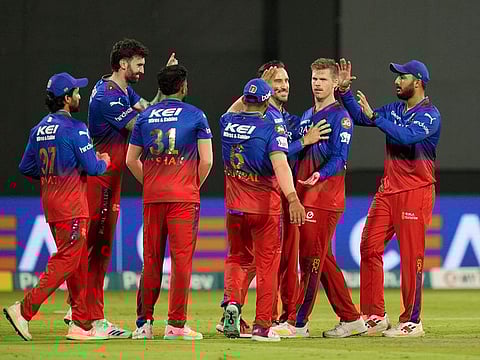 Royal Challengers Bengaluru players celebrate the wicket of Travis Head of Sunrisers Hyderabad during Match 30 on Monday.