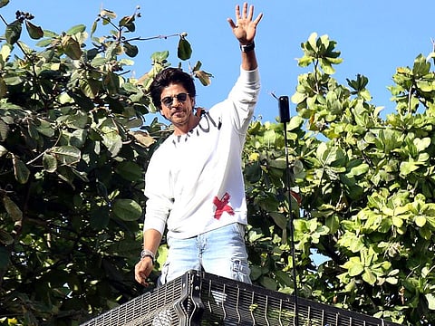 Bollywood actor Shah Rukh Khan waves to the fans who were gathered outside his home at Mannat, in Mumbai