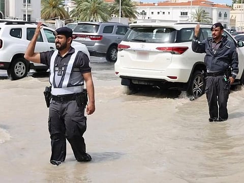 Still from clip posted by Abu Dhabi Media Office on X showing policemen managing traffic after the rain