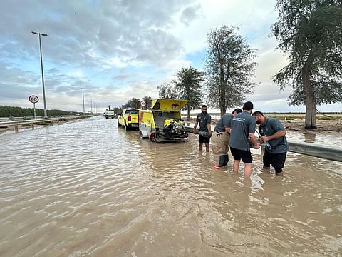 Ready to help: Officials come to the rescue of stranded motorists as rains lashed the UAE on Tuesday.