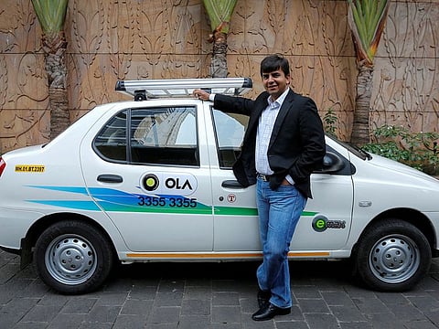 Bhavish Aggarwal, CEO and co-founder of Ola, an app-based cab service provider, poses in front of an Ola cab in Mumbai.