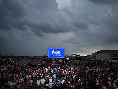 Supporters of former US President and 2024 Republican presidential candidate Donald Trump are asked to move to a shelter as a storm moves in before Trump's speech at a campaign rally in Wilmington, North Carolina.