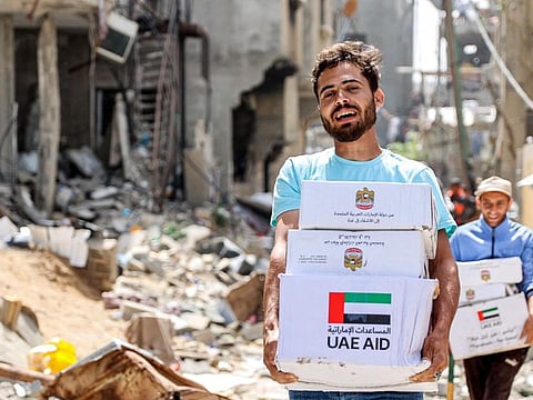 Men walk through rubble past damaged buildings with humanitarian aid packages collected from a drop over the northern Gaza Strip on April 23, 2024 amid the ongoing conflict in the Palestinian territory between Israel and the militant group Hamas.