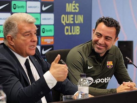 FC Barcelona President Joan Laporta (left) and Barcelona's Spanish coach Xavi address a press conference at the Joan Gamper training ground in Sant Joan Despi, near Barcelona, on Thursday.