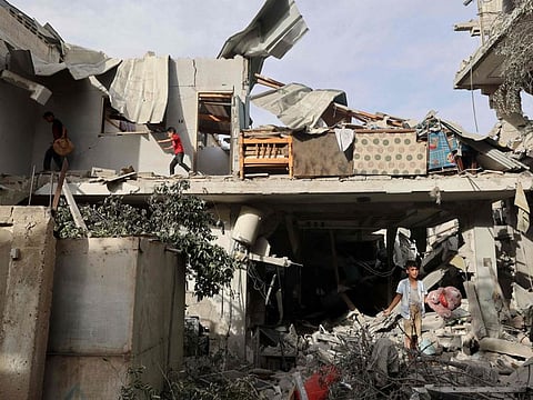 Palestinian children search the rubble of a building hit in overnight Israeli bombardment in Rafah in the southern Gaza Strip, on April 25, 2024.