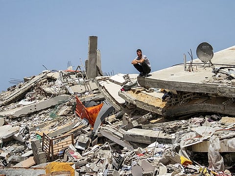 A Palestinian man sits on the rubble of a house destroyed by Israeli strikes, amid the ongoing conflict between Israel and Hamas, in the northern Gaza Strip, April 22, 2024.