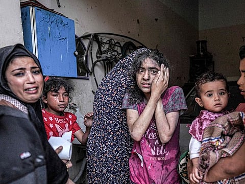 A woman and children react following Israeli bombardment in Nuseirat in the central Gaza Strip on April 29, 2024.