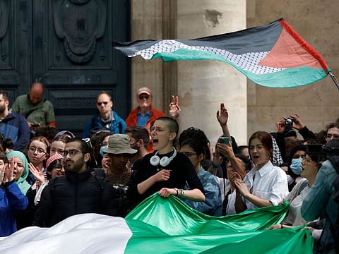 Students shout slogans and display a giant Palestinian flag as they take part in a rally in support of Palestinians at the Sorbonne University in Paris on April 29, 2024.