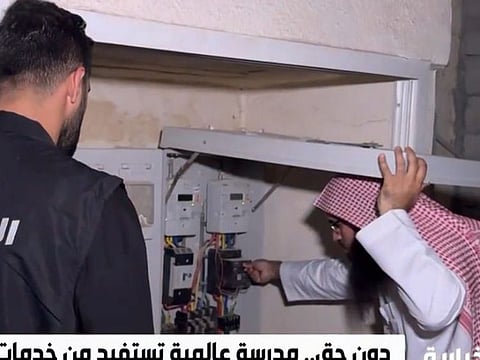 A Saudi official checks the electricity meter during investigation.
