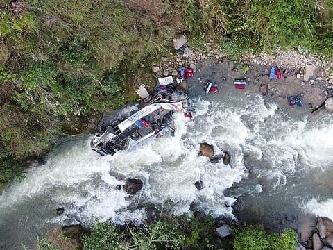 The wreckage of a passenger bus remains at the bottom of a ravine after plunging from a mountain road in the Andean region of Cajamarca, Peru, on April 29, 2024.
