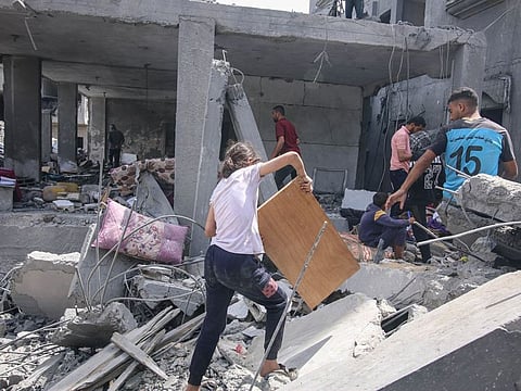 Palestinians sort through the rubble of destroyed buildings following an Israeli airstrike in a residential neighborhood at the Nuseirat refugee camp, central Gaza.