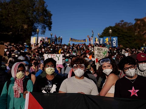 Pro-Palestinian protesters stand on stairs near an encampment at the University of California, Los Angeles (UCLA) campus on May 2, 2024, in California.