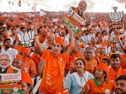 Supporters hold cut-outs of Lotus, the symbol of Bharatiya Janata Party (BJP) and India's Prime Minister Narendra Modi during an election campaign rally, in Anand, India, May 2, 2024. REUTERS/Amit Dave