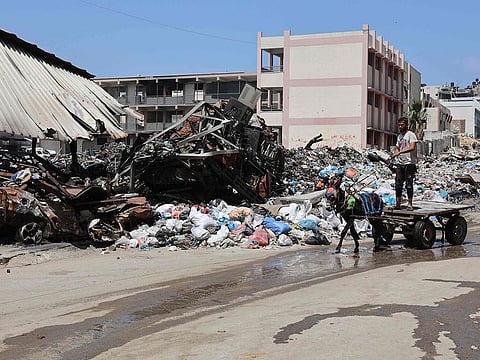 A Palestinian rides a donkey-pulled cart past a rubbish dump in Gaza City on May 3, 2024, amid the ongoing conflict between Israel and the militant group Hamas.