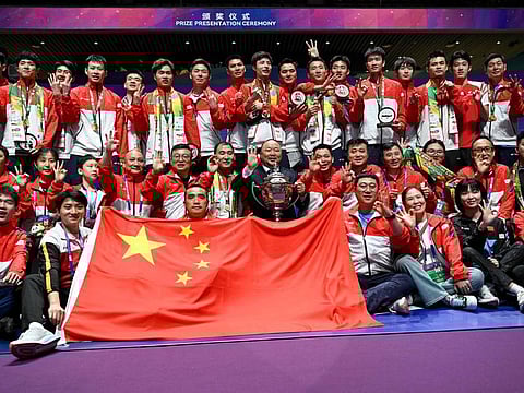 Members of Chinese badminton team pose for a picture with the trophy after their victory over Indonesia in the Thomas and Uber Cup badminton tournament in Chengdu, on Sunday.