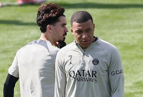 Paris Saint-Germain's French forward Kylian Mbappe (right) with midfielder Vitinha during a training session at the "campus" of Poissy, western Paris, on Monday.