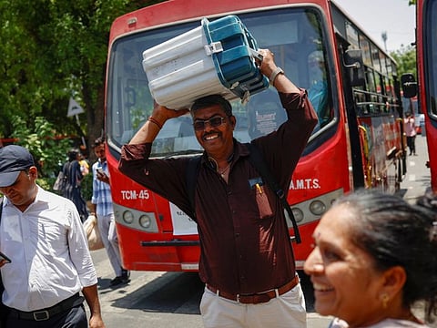 Polling officials carry election materials after collecting them at a distribution centre as they walk towards their designated vehicle, ahead of the third phase of the general elections, in Ahmedabad, India, May 6, 2024.