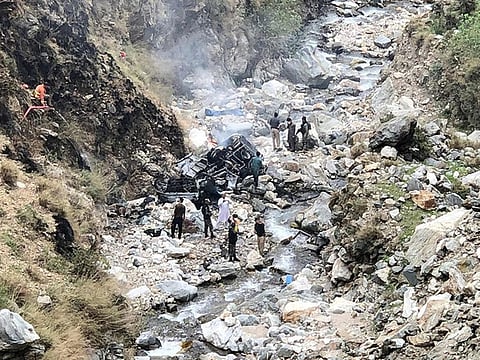 Security officials inspect the wreckage of a vehicle which was carrying Chinese engineers that plunged into a deep ravine off the mountainous Karakoram Highway after a suicide attack near Besham city in the Shangla district of Khyber Pakhtunkhwa province on March 26, 2024.