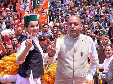 Bharatiya Janata Party (BJP) candidate from Mandi seat Kangana Ranaut shows a victory sign with Leader of Opposition in Himachal Pradesh Assembly Jairam Thakur during an election rally for the third phase of the Lok Sabha polls, at Thunag, in Mandi on Monday.
