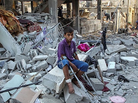 A wounded Palestinian sits on debri at the site of an Israeli strike on a house, amid the ongoing conflict between Israel and the Palestinian Islamist group Hamas, in Rafah, in the southern Gaza Strip May 9, 2024.