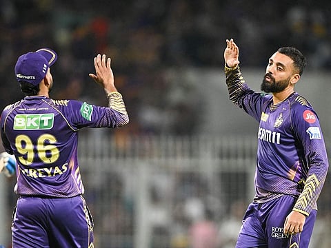 Kolkata Knight Riders' Varun Chakravarthy (R) celebrates with captain Shreyas Iyer after taking the wicket of Mumbai Indians' Rohit Sharma during the Indian Premier League (IPL) match at the Eden Gardens in Kolkata on May 11, 2024.