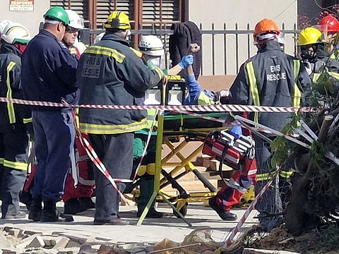 A man raises his hand as rescue workers carry him to an ambulance after being rescued, having survived 116 hours after a deadly building collapse in George, South Africa May 11, 2024.