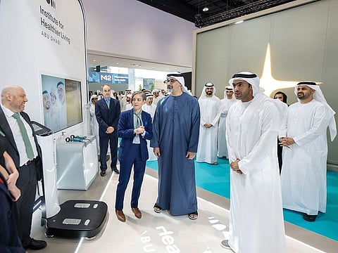 Sheikh Khaled bin Mohamed bin Zayed Al Nahyan (C), Crown Prince of Abu Dhabi and Chairman of Abu Dhabi Executive Council, accompanied by Sheikh Theyab bin Mohamed bin Zayed Al Nahyan (far right), Deputy Chairman of the Presidential Court for Development and Fallen Heroes' Affairs, during a tour of the exhibition on Monday