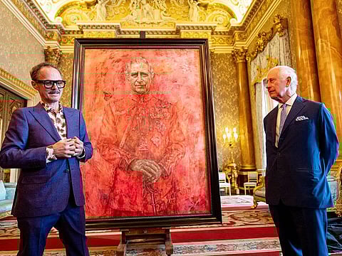 Britain's King Charles meets with artist Jonathan Yeo next to a portrait of the king, at Buckingham Palace, London, on May 14, 2024.