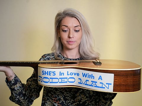 Claire Tole-Moir, head of Bonham's Popular Culture department, poses for a photograph with Eric Clapton's 1974 000-28 Martin acoustic guitar, on which he wrote the song "Wonderful Tonight", at Bonhams auction house, ahead of "Rock, Pop & Film" auction on June 12, in London, Britain May 13, 2024.