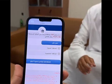 An Omani resident shows the message on his mobile, expressing his his joy over the waiver of his fines.