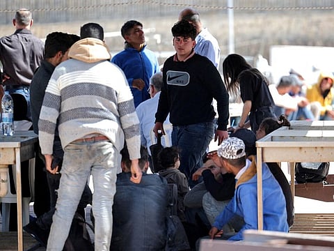 Migrants wait at a fishing shelter in Paralimni, Cyprus, April 5, 2024. The island has seen an unprecedented influx of hundreds of refugees from Syria, whom Cypriot authorities said set off from the coast of Lebanon, last month.