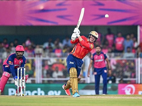 Punjab Kings' captain Sam Curran (centre) in action as his Rajasthan Royals' counterpart and wicketkeeper Sanju Samson watches during the Indian Premier League (IPL) Twenty20 cricket match at the Assam Cricket Association Stadium in Guwahati on Wednesday.