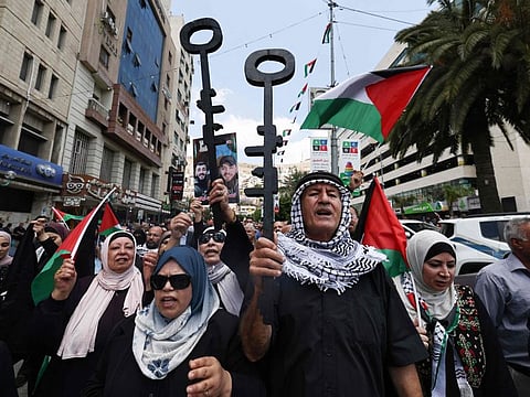 Palestinian protesters hold symbolic keys during a rally in the northern West Bank city of Nablus on May 15, 2024, marking the 76th anniversary of the "Nakba" or "Catastrophe" of the creation of Israel, which sparked the exodus of hundreds of thousands of Palestinians in 1948.
