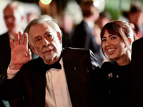 US director Francis Ford Coppola (L) waves at fans as he leaves after the screening of the film "Megalopolis" at the 77th edition of the Cannes Film Festival in Cannes, southern France, on May 16, 2024
