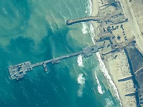 This handout picture courtesy of the US Central Command (CENTOCOM) taken on May 16, 2024 shows US Army Soldiers assigned to the 7th Transportation Brigade (Expeditionary), US Navy Sailors assigned to Amphibious Construction Battalion 1, and Israel Defense Forces emplace the Trident Pier on the Gaza coast.