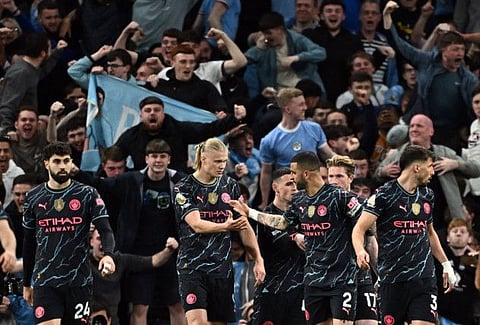 Manchester City's Erling Braut Haaland celebrates scoring their first goal with Kyle Walker during a Premier League match against Tottenham Hotspur on May 14.