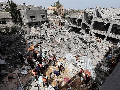 Palestinians inspect the site of an Israeli strike on a house, in Nuseirat, in the central Gaza Strip, on May 19, 2024.
