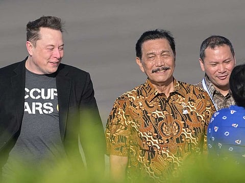 Tech billionaire Elon Musk (left) walks with Indonesia's Coordinating Minister of Maritime and Investment Affairs Luhut Binsar Pandjaitan (centre) during his arrival at Ngurah Rai International airport in Denpasar on Indonesia's Bali island on May 19, 2024.