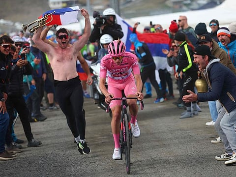 Pink jersey Team UAE's Slovenian rider Tadej Pogacar climbs surrounded by fans to win the 15th stage of the 107th Giro d'Italia cycling race, 222km between Manerba del Garda and Mottolino on May 19.