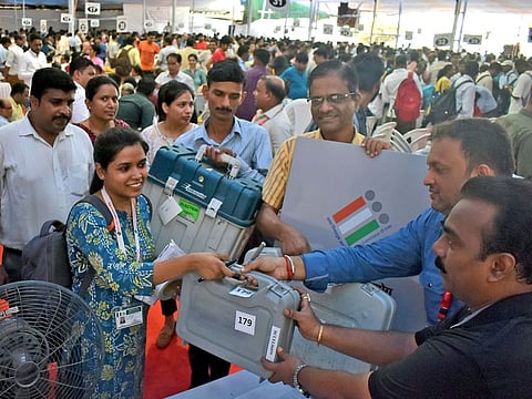 Polling officials collect the election materials before leaving for their respective polling station on the eve of the fifth phase of the Lok Sabha Polls, at a distribution centre in Mumbai on Sunday.