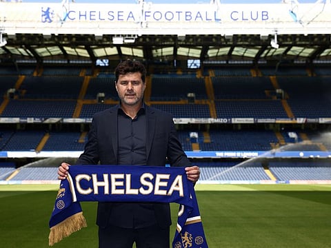Chelsea's Argentinian head coach Mauricio Pochettino poses for a photograph with a Chelsea scarf beside the pitch at Stamford Bridge in London on July 7, 2023.