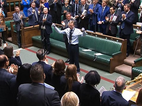 A video grab from footage broadcast by the UK Parliament's Parliamentary Recording Unit (PRU) shows Britain's Conservative MP Craig Mackinlay acknowledging the applauses and cheering, in the House of Commons, in London, on May 22, 2024 on the day of his coming back ahead of the weekly session of Prime Minister's Questions (PMQs) in the House of Commons.
