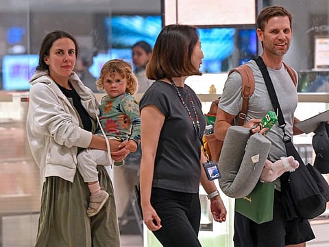 Passengers of Singapore Airlines flight SQ321 from London to Singapore, which made an emergency landing in Bangkok, are escorted by ground staff upon arrival at Changi Airport in Singapore on May 22, 2024.