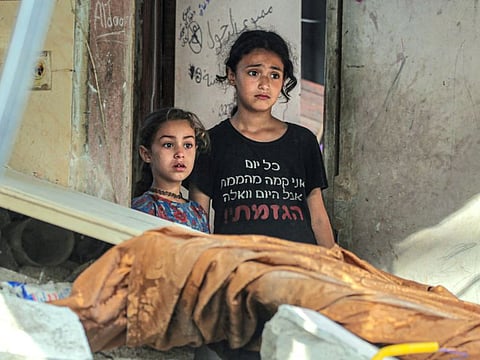 Palestinian children react as they look at the damage in Nuseirat following Israeli bombardment overnight on May 23, 2024, amid continuing battles between Israel and Hamas in the Gaza Strip.
