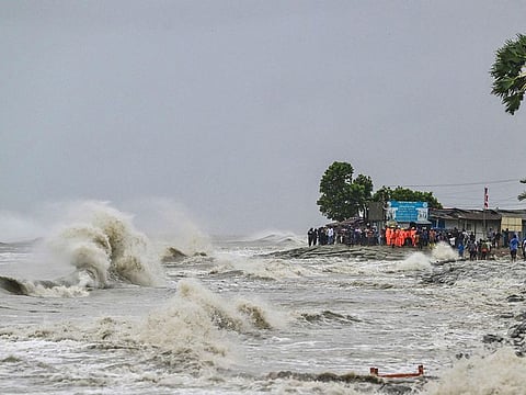 People gather along the sea shore amid rainfall in Kuakata in Bangladesh.
