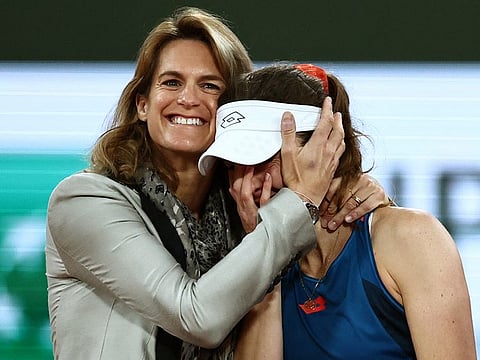 France's Alize Cornet (right) gets emotional as Roland-Garros Open tennis tournament's director Amelie Mauresmo hugs her after her women's singles match on Court Philippe-Chatrier against China's Zheng Qinwen at the Roland Garros Complex in Paris on Tuesday.
