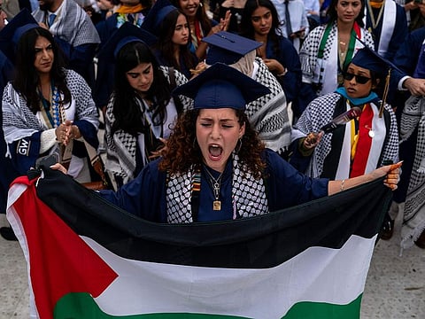 Students protest as they walk out from the George Washington University (GWU) commencement ceremony as GWU President Ellen Granberg speaks on the National Mall on May 19, 2024 in Washington, DC. Student protests across university campuses have continued with walkouts occurring during commencement ceremonies as part of a coordinated effort to demand that institutions of higher education divest from companies and endowments with ties to Israel, amid Israel's continued siege of Gaza