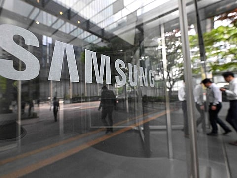 File photo: People walk past the Samsung logo displayed on a glass door at the company's Seocho building in Seoul.