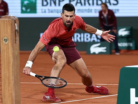 Serbia's Novak Djokovic plays a backhand return to France's Pierre-Hugues Herbert during their men's singles match on Court Philippe-Chatrier at the Roland Garros Complex in Paris on May 28.