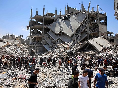 Palestinians carry some salvaged belongings as they leave the Jabalia refugee camp in the northern Gaza Strip after they returned briefly to check on their homes on May 30, 2024, amid the ongoing conflict between Israel and the militant group Hamas.
